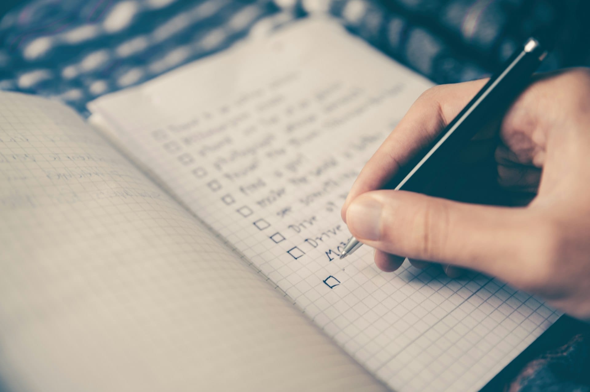 A person writing a list in a notebook
